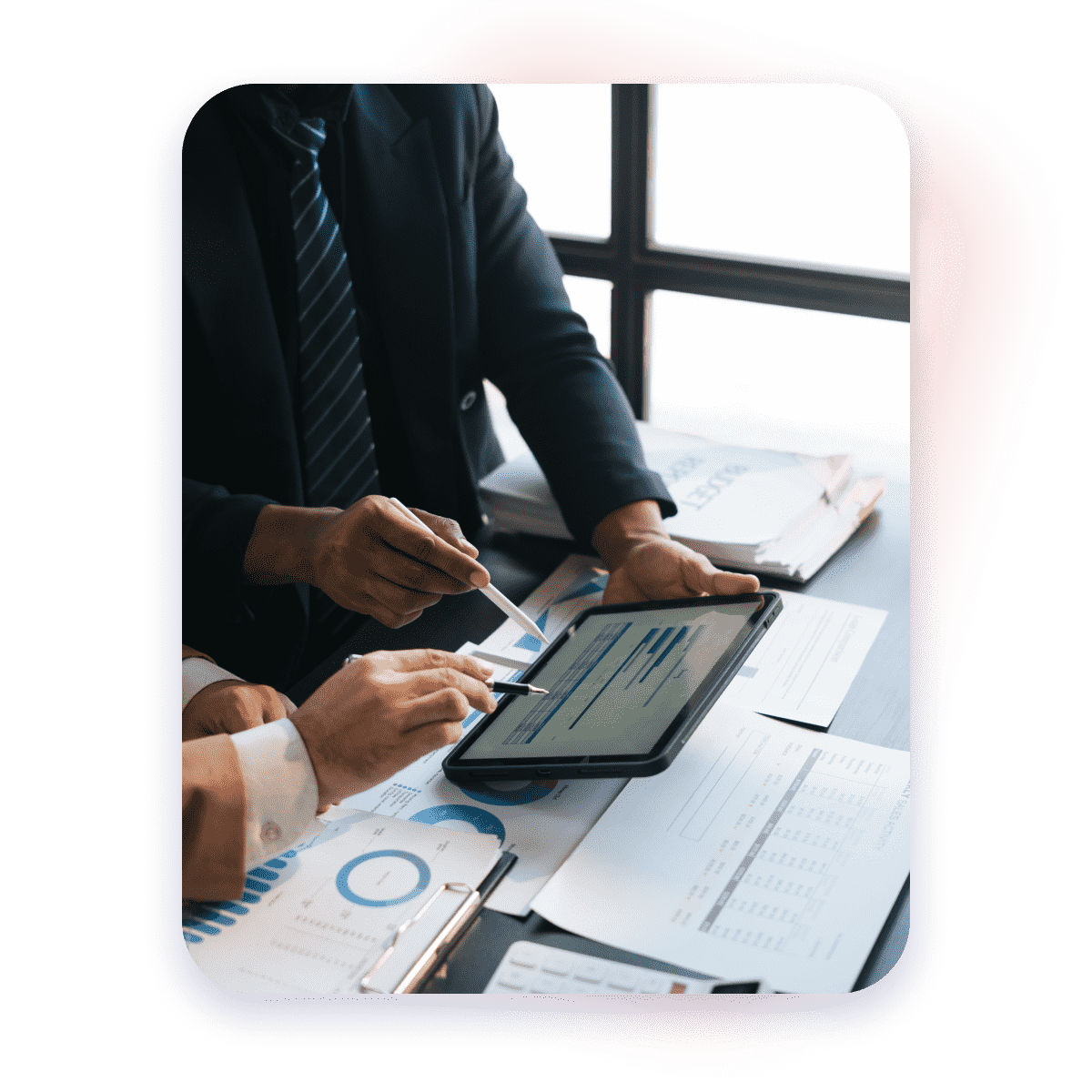 2 people hands close up pointing at a tablet showing charts and analytics